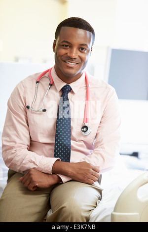 Porträt von männlichen Arzt sitzen am Krankenhausbett Stockfoto