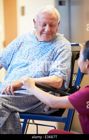 Senior männlichen Patienten im Rollstuhl von Krankenschwester gedrängt Stockfoto