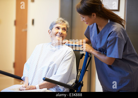 Ältere Patientin von Krankenschwester im Rollstuhl geschoben Stockfoto