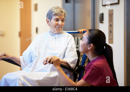 Ältere Patientin von Krankenschwester im Rollstuhl geschoben Stockfoto