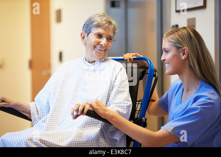 Ältere Patientin von Krankenschwester im Rollstuhl geschoben Stockfoto