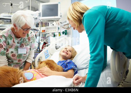 Junge Mädchen, die im Krankenhaus von Therapiehund besucht Stockfoto