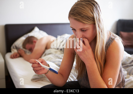 Teenager-Mädchen im Schlafzimmer besorgt mit Schwangerschaft Test-Kit Stockfoto