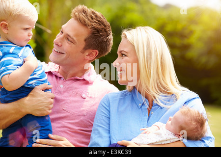 Eltern mit kleinen Kindern im Garten Stockfoto