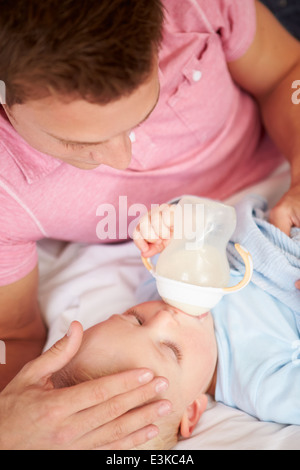 Vater Sohn Babyflasche Milch geben Stockfoto