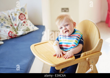 Baby Boy im Hochstuhl sitzen Stockfoto