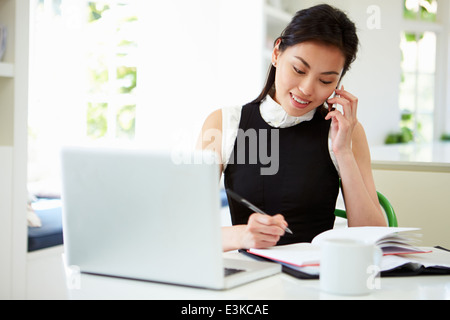 Asiatische Geschäftsfrau Arbeiten von Hause mit Handy Stockfoto