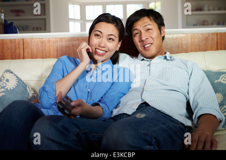 Asiatische paar sitzt auf dem Sofa vor dem Fernseher zusammen Stockfoto