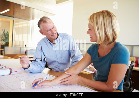 Architekten, die Pläne In modernen Büro gemeinsam studieren Stockfoto