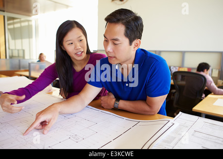 Architekten, die Pläne In modernen Büro gemeinsam studieren Stockfoto