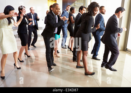 Unternehmer und Unternehmerinnen im Büro Lobby tanzen Stockfoto