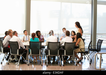 Geschäftsfrau, die Adressierung treffen um Konferenztisch Stockfoto