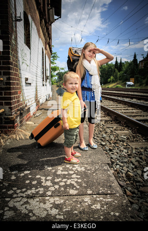 Kinder warten auf den Zug auf einem Bahnhof Stockfoto