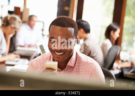 Geschäftsmann, arbeiten am Schreibtisch mit Handy Stockfoto