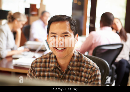 Geschäftsmann, arbeiten am Schreibtisch mit treffen im Hintergrund Stockfoto