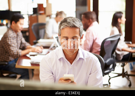 Geschäftsmann, arbeiten am Schreibtisch mit Handy Stockfoto