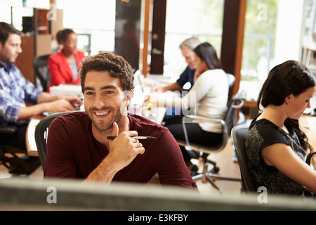 Geschäftsmann, arbeiten am Schreibtisch mit treffen im Hintergrund Stockfoto