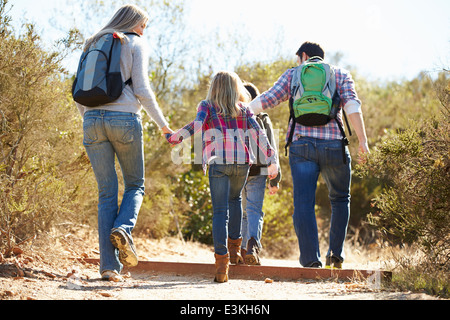 Rückansicht der Familie Wandern im Land tragen Rucksäcke Stockfoto