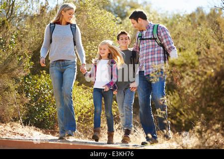 Familie Wandern im Land tragen Rucksäcke Stockfoto