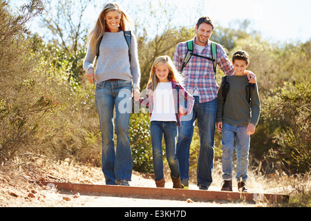 Familie Wandern im Land tragen Rucksäcke Stockfoto