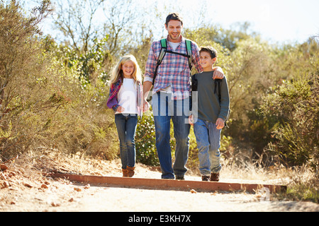 Vater und Kinder Wandern im Land tragen Rucksäcke Stockfoto