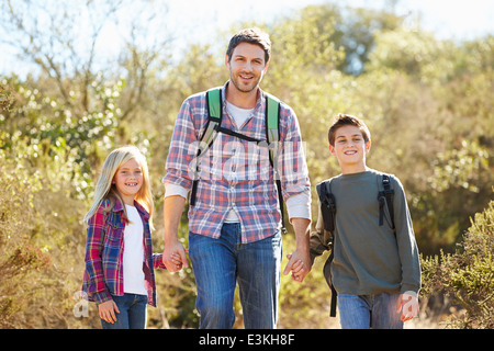Vater und Kinder Wandern im Land tragen Rucksäcke Stockfoto