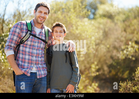 Vater und Sohn wandern im Land tragen Rucksäcke Stockfoto