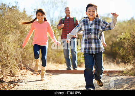 Vater und Kinder Wandern im Land tragen Rucksäcke Stockfoto