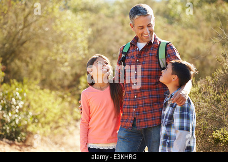 Vater und Kinder Wandern im Land tragen Rucksäcke Stockfoto