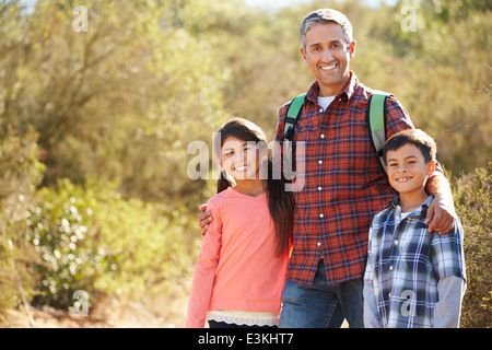 Vater und Kinder Wandern im Land tragen Rucksäcke Stockfoto