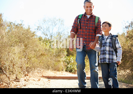 Vater und Sohn wandern im Land tragen Rucksäcke Stockfoto