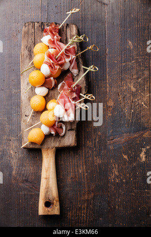 Mozzarella, Schinken, Melone Kanapees auf strukturierten Hintergrund Stockfoto