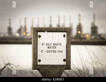 Ölige Abwasser-Pipeline-Marker mit Conoco Phillips Raffinerie im Hintergrund bei Seal Sands, Teesside, England. UK Stockfoto