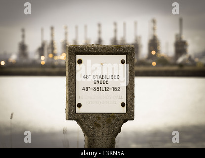 Stabalisierte Rohölpipeline-Markierung mit Conoco Phillips-Raffinerie im Hintergrund bei Seal Sands, Teesside, England. VEREINIGTES KÖNIGREICH Stockfoto