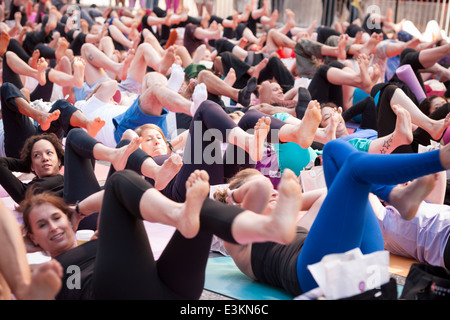 Tausende von Yoga-Praktizierende packen Times Square in New York zur Teilnahme an einem Power-Yoga-Kurs am ersten Tag des Sommers Stockfoto