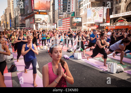 Tausende von Yoga-Praktizierende packen Times Square in New York zur Teilnahme an einem Power-Yoga-Kurs am ersten Tag des Sommers Stockfoto