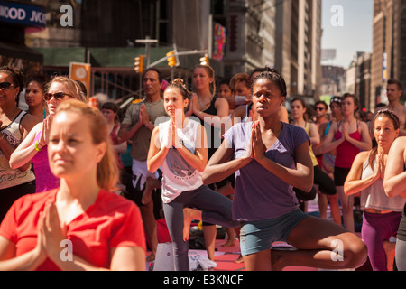Tausende von Yoga-Praktizierende packen Times Square in New York zur Teilnahme an einem Power-Yoga-Kurs am ersten Tag des Sommers Stockfoto