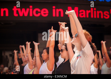 Tausende von Yoga-Praktizierende packen Times Square in New York zur Teilnahme an einem Power-Yoga-Kurs am ersten Tag des Sommers Stockfoto