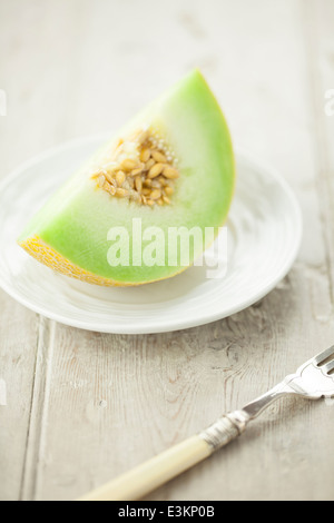 Galia Melone Slice auf weißen Teller Stockfoto