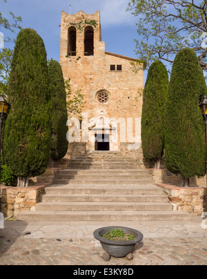 Flankiert von hohen Hecken, die Kumpels Kircheneingang. Stufen führen hinauf zu der strengen Stein Kirchenburg in diesem Dorf Stockfoto