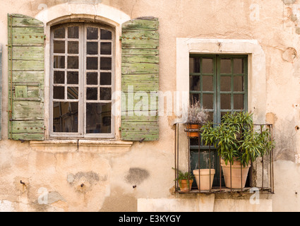 Ausschnitt aus der Wand eines Hauses in einem provenzalischen Dorf. Grobe Stuck Wand, Fenster und Balkon. Typisches Dorfhaus in der Provence Stockfoto