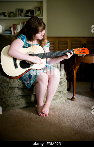 Bild von Teenager-Mädchen (13-15) spielt akustische Gitarre zu Hause Stockfoto