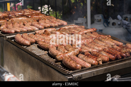 Würstchen auf dem Grill kochen. Viel Fleisch Rohre für die Massen an der St.-Antony-Parade vorbereitet Stockfoto