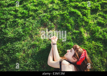 Junge Frau liegt auf dem Rasen Stockfoto