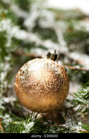 Goldene Weihnachtskugel Ornament auf Kiefer Blätter Nahaufnahme Stockfoto