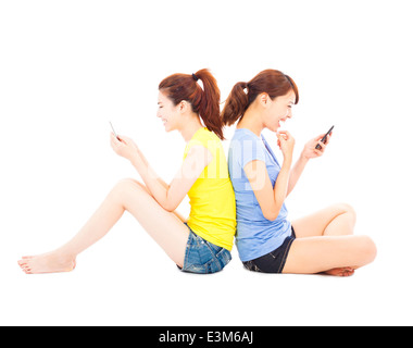 zwei glückliche hübsche Mädchen spielen Smartphone Stockfoto