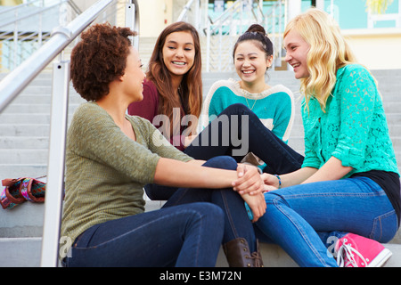 Weibliche High Studenten sitzen außen Schulgebäude Stockfoto