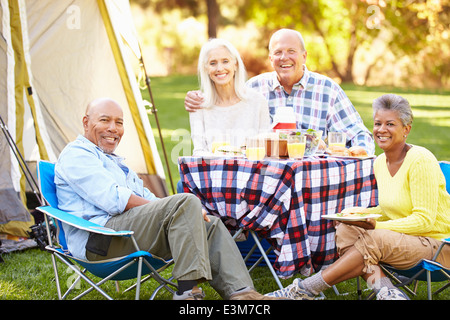 Zwei ältere Ehepaare genießen Camping-Urlaub In Natur Stockfoto