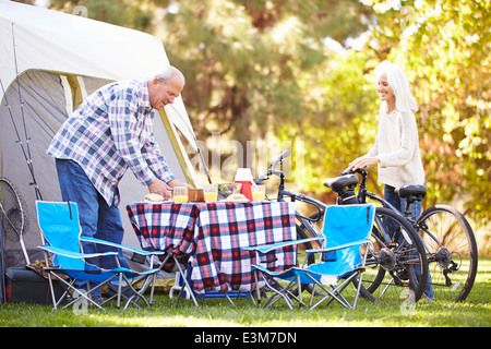 Älteres Paar Reiten Fahrräder auf Campingurlaub In Landschaft Stockfoto