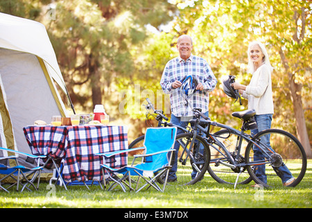 Älteres Paar Reiten Fahrräder auf Campingurlaub In Landschaft Stockfoto